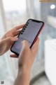 A person holding a cell phone with a keyboard on the screen.