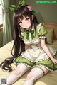 A girl in a green dress sitting on a bed.