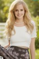 A young woman in a white top and black skirt posing for a picture.