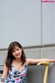 A woman leaning against a wall with her hand on a railing.