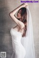 A woman in a white wedding dress with a long veil.