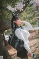 A woman wearing a cat ears headband and carrying a backpack.