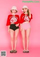 Two young women standing next to each other on a pink background.