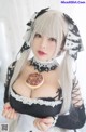 A woman in a maid outfit holding a donut.