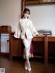 A woman in a white and red kimono posing for a picture.