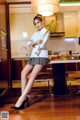 A woman in a white shirt and skirt holding a bunch of vegetables.