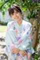 A woman in a blue and pink kimono posing for a picture.