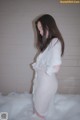 A woman standing in a bathtub covered in foam.