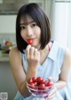 A woman holding a bowl of cherry tomatoes in her hand.