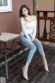 a woman sitting on top of a wooden floor next to a table