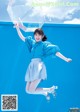 A woman jumping in the air holding an umbrella.