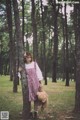 A girl in a red and white dress holding a teddy bear.
