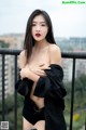 A woman in a black shirt and shorts posing on a balcony.